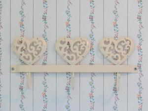 three wooden hearts on a shelf with flowers at Kornblume_DH in Röbel