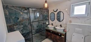 a bathroom with two sinks and a shower at Dãnu Guesthouse in Kravany nad Dunajom +38 photos