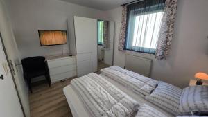 a bedroom with two beds and a desk and window at WarenERleben in Waren