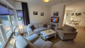 a living room with two couches and a tv at Ferienhaus Wennmann in Waren