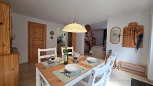 a dining room with a table with white chairs and a light at Ferienhaus Wennmann in Waren +19 photos