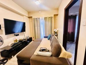 a living room with a couch and a flat screen tv at Haku Haven in Baguio