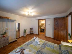 a bedroom with a large bed and a kitchen at L'Uggetto in Montecastrilli