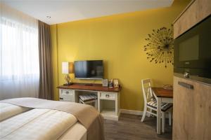 a hotel room with a bed and a desk with a television at Hotel Apartment Central Leipzig-City & Zoo in Leipzig
