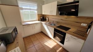 a small kitchen with a sink and a microwave at Ferienhaus Buche im Land Fleesensee in Göhren-Lebbin