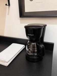 a coffee maker sitting on a table next to a napkin at Hostal Boutique Zona Rosa - San Benito in San Salvador