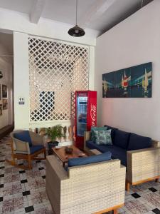 a living room with a blue couch and a coke machine at Casa 1811 in Cartagena de Indias