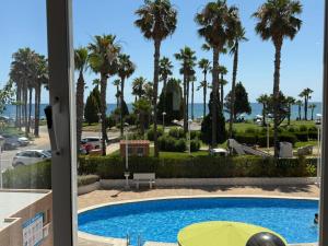 a view from a hotel room with a pool and palm trees at Magic World Frontal 1ª línea in Oropesa del Mar