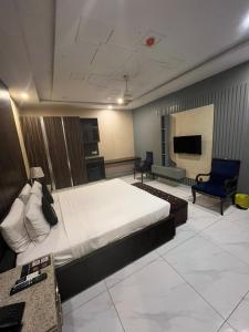 a hotel room with a bed and a tv at Palmtree Hotel in Lahore