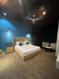 a bedroom with a bed in a blue room at Palmtree Hotel in Lahore +20 photos