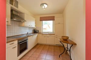 a kitchen with white cabinets and a table and a window at Ferienhaus Fernweh in Göhren-Lebbin