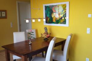 a dining room with a wooden table and white chairs at Fair-Play App 04 DG R in Göhren-Lebbin