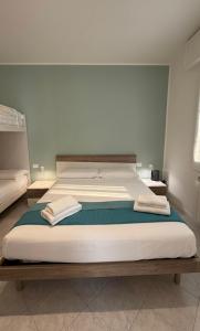 a large bed with two towels on it in a room at Casa Lanterna - Sottomarina in Chioggia