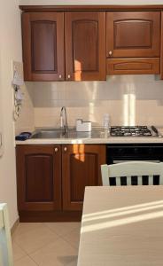 a kitchen with wooden cabinets and a sink and a stove at Casa Lanterna - Sottomarina in Chioggia