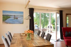 a dining room with a wooden table and chairs at Ferienhaus Fernweh in Göhren-Lebbin