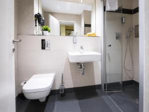 a bathroom with a sink and a toilet and a shower at Hotel Apartment Central Leipzig-City & Zoo in Leipzig