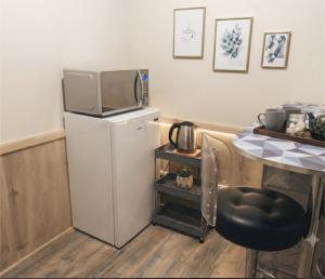 a kitchen with a refrigerator with a tv on top of it at "Aux Portes de CDG" in Thieux