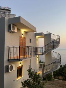 a building with stairs and a view of the ocean at Villa Denis Gjeta in Borsh