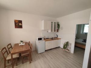 a kitchen and dining room with a table and a small kitchen at Za hrází Poděbrady in Poděbrady