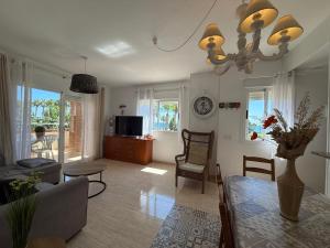 a living room with a couch and a dining room table at Magic World Frontal 1ª línea in Oropesa del Mar