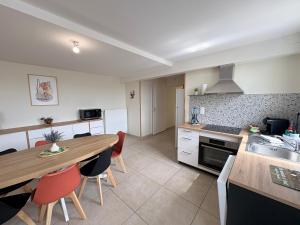 a kitchen with a wooden table and a dining room at Le Cerf in Montmacq +9 photos