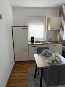 a kitchen with a table and a kitchen with a counter at Ferienwohnung Mia in Büchlberg