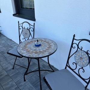 a table with two chairs and a table with a bowl on it at Ferienwohnung Mia in Büchlberg