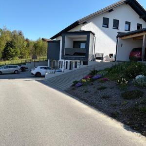 a house with two cars parked in a parking lot at Ferienwohnung Mia in Büchlberg