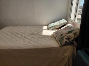 a bed with two pillows on it in a room at Résidence Al-amine in Koungou