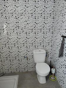 a bathroom with a white toilet and a black and white wallpaper at Résidence Al-amine in Koungou