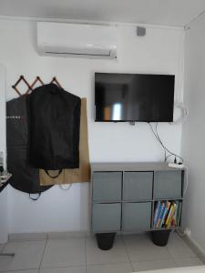 a tv on a wall with a dresser with a television on it at Résidence Al-amine in Koungou