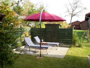 a patio with two chairs and a table with an umbrella at Ferienhaus Jabel 24 in Jabel