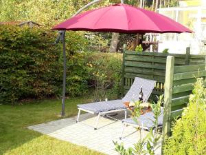 a red umbrella sitting next to a chair and a table at Ferienhaus Jabel 24 in Jabel