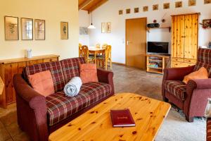 a living room with two couches and a wooden table at Ferienhaus Jabel 25 in Jabel