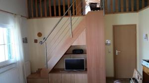 a living room with a staircase with a television at Ferienhaus Jabel 25 in Jabel +5 photos