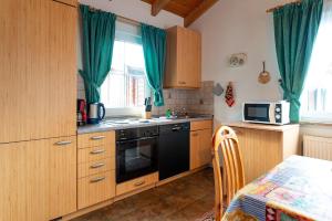 a kitchen with wooden cabinets and a stove and a microwave at Ferienhaus Jabel 26 in Jabel