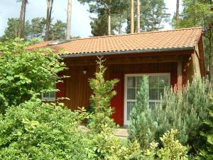 a small red house in the middle of a garden at Ferienhaus Jabel 26 in Jabel