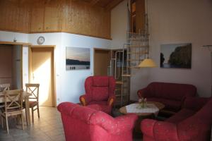 a living room with red chairs and a table at Ferienhaus Jabel 29 in Jabel