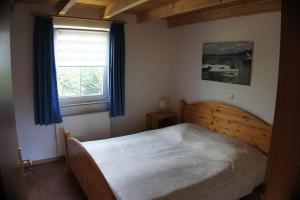 a bedroom with a wooden bed and a window at Ferienhaus Jabel 29 in Jabel