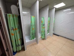 a row of green shower curtains in a room at Summer hostel in Ulaanbaatar