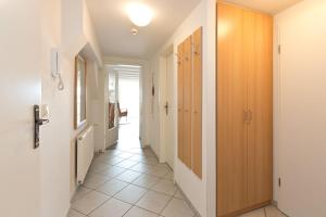 a hallway with wooden doors and a tile floor at Kietzspeicher App 06 in Waren +15 photos