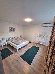 a bedroom with a bed and two rugs on the floor at Levendula Porta in Balatonfůzfő