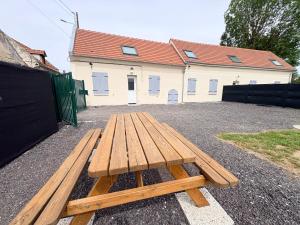 a wooden picnic table sitting in front of a building at Le Cerf in Montmacq
