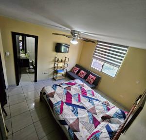 a bedroom with a bed with a quilt on it at Departamento amoblado Tonsupa in Tonsupa +60 photos