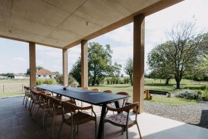 a dining table and chairs on the patio of a house at Das Sonnengleis in Lutzmannsburg