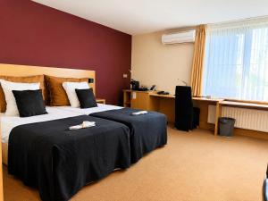 a hotel room with a bed and a desk at Axis Hotel Brussels Airport in Kortenberg