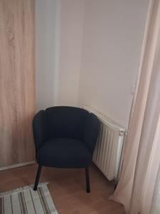 a blue chair sitting in a corner of a room at Apartments Vlado in Njivice