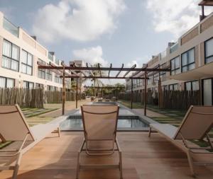 a patio with chairs and a pool in a building at Atins Ville Lençóis in Atins