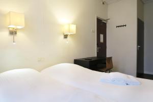 Postel nebo postele na pokoji v ubytování Hotel Carillon