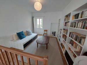 a living room with a couch and a book shelf at Gite des Anglais in Marnay +5 photos
